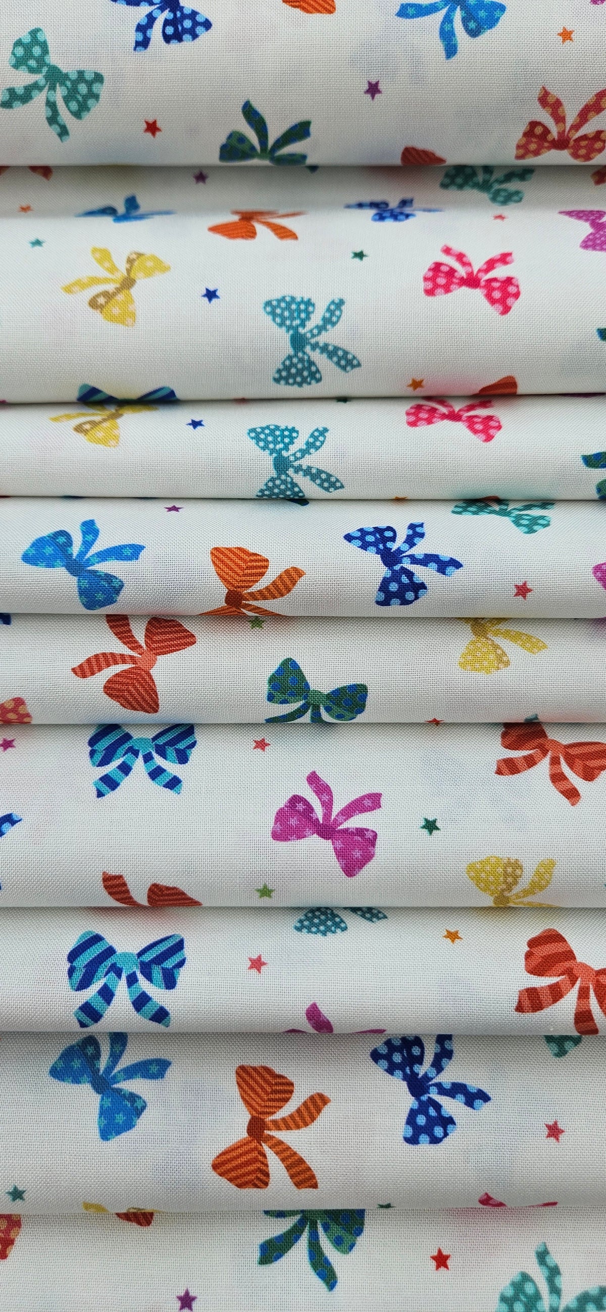Lewis & Irene Small Things Celebrations Bows cotton fabric with colourful bows and stars on white