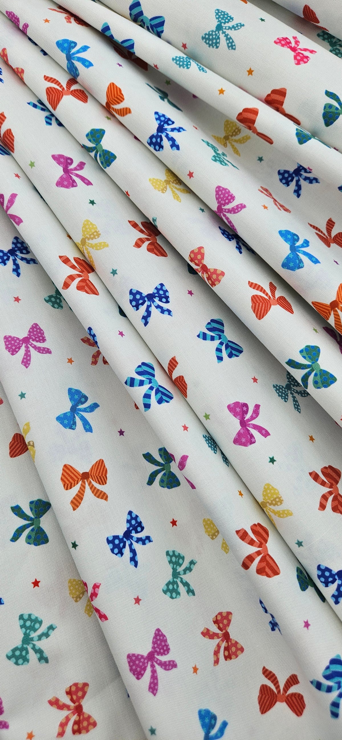 Lewis & Irene Small Things Celebrations Bows cotton fabric with colourful bows and stars on white